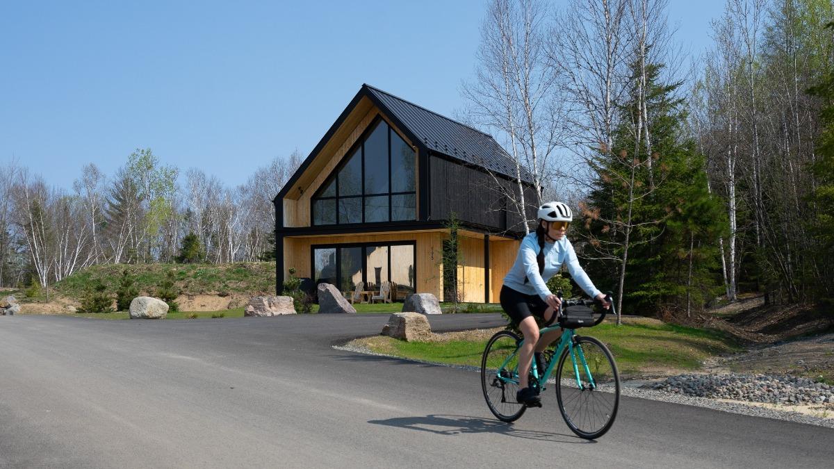 A woman biking outside of a vacation rental in Mont-Tremblant